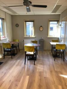 a dining room with tables and chairs and windows at Bed en Breakfast 1394 in Nederhorst den Berg