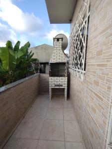 a balcony with a grill on a brick wall at Moradas Araújo in Camboriú