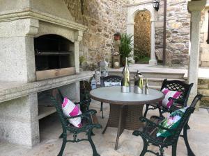 eine Terrasse mit Tisch und Stühlen und einem Ofen in der Unterkunft Casa De Cacheiro in Silleda