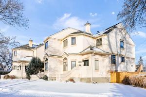 ein großes weißes Haus im Schnee in der Unterkunft Chic Central 4BDRM Home-King Bed-AirHockey-Mins DT in Edmonton
