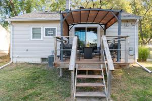 a deck with a staircase leading up to a house at Enchanting 3BR Cottage Close to Downtown in Omaha