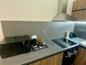 a kitchen with a black microwave and a sink at Pegazus Apartman in Keszthely