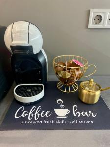 a coffee tram sign on a counter next to a coffee maker at Pegazus Apartman in Keszthely