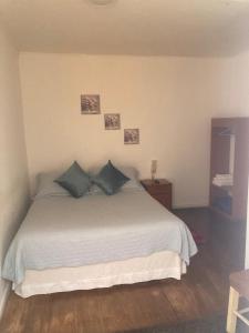 a bedroom with a white bed with blue pillows at Hotel Ruiz Angol in Angol +4 photos