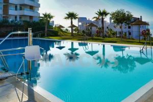a swimming pool with blue water in a resort at South facing sea views Isea in Torrox Costa