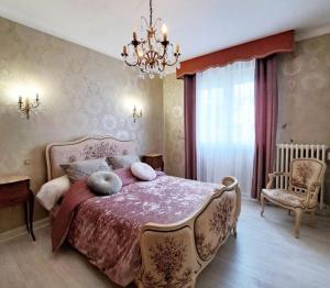 a bedroom with a large bed and a chandelier at La Villa Reina in Le Croisic