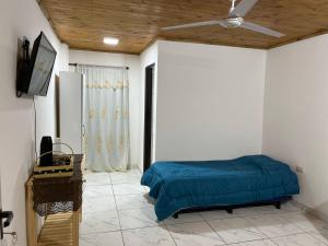 a bedroom with a bed and a ceiling fan at Yateí in Puerto Iguazú