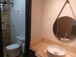 a bathroom with a sink and a toilet and a mirror at Sonildes in Rio Verde