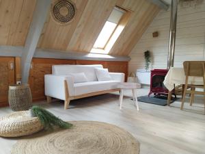 a living room with a white couch and a fireplace at Quercynoise de Charme Piscine et vue sur Vallée du LOT in Balaguier-dʼOlt