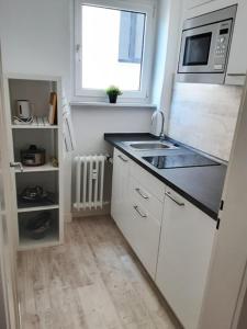 a small kitchen with a sink and a microwave at City Appartement in Ulm Old City-Center in Ulm