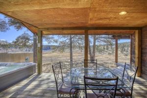 una veranda riparata con tavolo, sedie e vasca idromassaggio di 811 County Rd 500 a Pagosa Springs