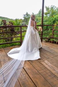 uma mulher num vestido de noiva sentada num convés em Casa Flôr em Fernando de Noronha