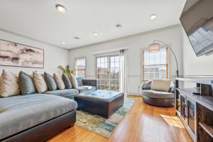 a living room with a couch and a table at HUGE Cozy Jersey City Oasis with Double Balcony - 20 mins to NYC in Jersey City