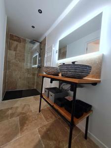 ein Badezimmer mit einer Dusche und einem Regal mit Körben in der Unterkunft Les Voiles Blanches, T3 neuf de 53 m2 in Saint-Jean-de-Monts