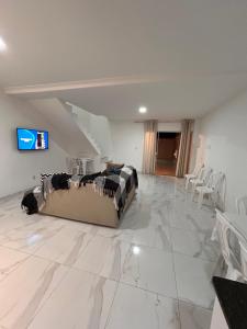 a living room with a couch on a marble floor at Casa com piscina em Jauá in Camaçari