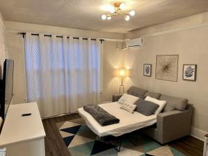 a living room with a bed and a couch at Cozy Tower Hideaway in Fresno