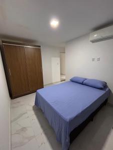 a bedroom with a bed with blue pillows on it at Casa com piscina em Jauá in Camaçari +9 photos