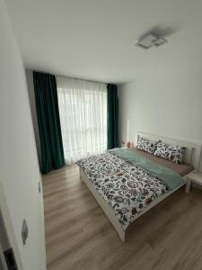 a bedroom with a bed and a window with green curtains at Victor's in Cluj-Napoca +3 photos