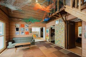 a living room with a couch and wooden walls at アルテミナガハク in Teshikaga