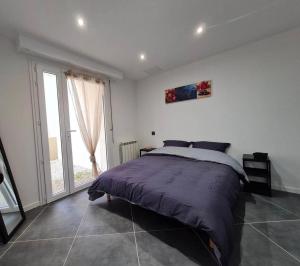 ein Schlafzimmer mit einem Bett und einem großen Fenster in der Unterkunft Les Voiles Blanches, T3 neuf de 53 m2 in Saint-Jean-de-Monts