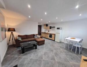 ein Wohnzimmer mit Sofa und eine Küche in der Unterkunft Les Voiles Blanches, T3 neuf de 53 m2 in Saint-Jean-de-Monts