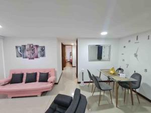 a living room with a pink couch and a table at Alojamiento Excepcional en zona Turística Vigo in Sabaneta