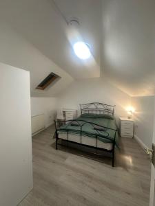 a bedroom with a bed and a lamp on a wooden floor at CR0 Purley Way Serviced Accommodation in Croydon
