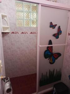 a shower with butterflies on the wall in a bathroom at Lobito in Puerto Baquerizo Moreno