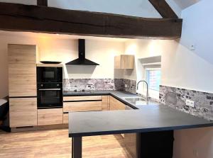 a kitchen with wooden cabinets and a counter top at Aux Tours du Gîte in Leval