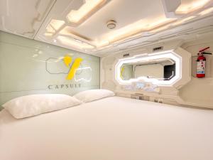 坎昆The Yellow Capsule Cancun Close to Airport的卧室里有一张白色的床和一面镜子