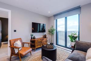 a living room with a couch and a large window at Leeds City Centre - Luxury 2 Bed - Free Parking in Leeds