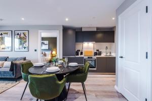 a kitchen and living room with a table and chairs at Leeds City Centre - Luxury 2 Bed - Free Parking in Leeds +43 photos