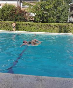 a young boy swimming in a swimming pool at Muy buen apartamento con parrilla y piscina, en country in Pilar