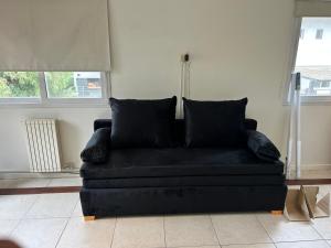 a black couch sitting in a living room at Muy buen apartamento con parrilla y piscina, en country in Pilar +29 photos