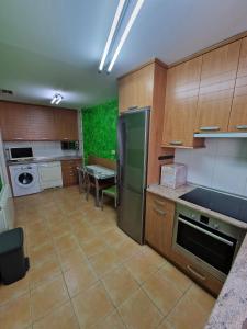 a kitchen with wooden cabinets and a stainless steel refrigerator at Gran piso en el centro de Huesca in Huesca