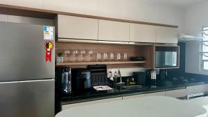 a kitchen with a black counter top and a refrigerator at Condomínio próximo a ponte Hercílio Luz in Florianópolis