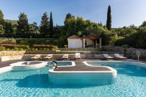 a swimming pool with chairs and a house at Holiday Home Korda in Gruda