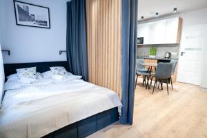 卡托维兹Flow Apartments - Świętego Pawła 10的一间卧室，配有一张床和一张桌子和椅子