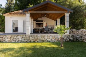 a house with a stone wall and a patio at Holiday Home Korda in Gruda