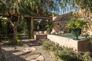 a backyard with a pool with two potted plants at Dèpendance Armonia - 100 meters walk from the beach in Donnalucata