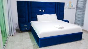 Hôtel détente assinie في أسيني: سرير مع اللوح الأمامي الأزرق في الغرفة