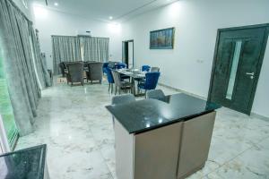 Hôtel détente assinie في أسيني: غرفة طعام مع طاولة وكراسي زرقاء +3 صور