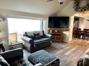 a living room with a couch and a flat screen tv at Paradise Suites The Wolf Den in Homer