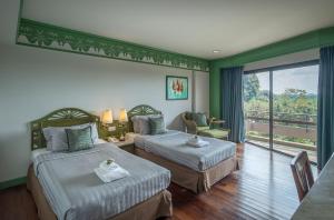 a hotel room with two beds and a balcony at Krabi Maritime Resort in Krabi town