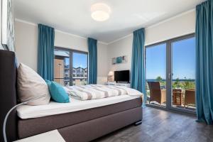 une chambre avec un lit et une grande fenêtre dans l'établissement Ostsee - Appartement Nr 80 "MeerSinn" im Strand Resort, à Heiligenhafen