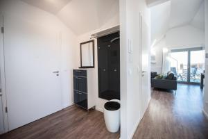 a living room with white walls and a black cabinet at Ostsee - Appartement Nr 65 "Seaside" inkl Strandkorb im Strand Resort in Heiligenhafen