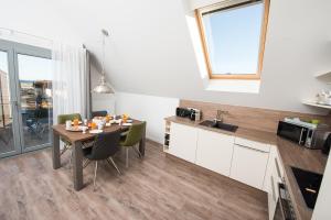 a kitchen and dining room with a table and chairs at Ostsee - Appartement Nr 65 "Seaside" inkl Strandkorb im Strand Resort in Heiligenhafen +17 photos