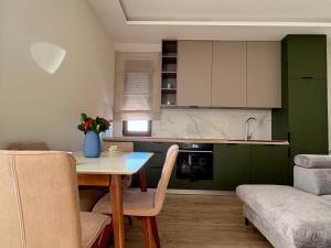 a kitchen with a table and chairs in a room at Apartmani Slijepčević in Tivat