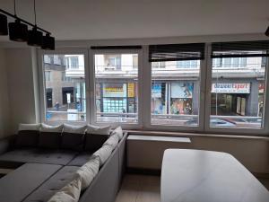 ein Wohnzimmer mit einer Couch vor einem Fenster in der Unterkunft Appartement in Ostende