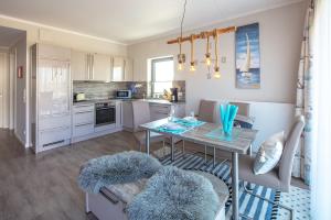 a kitchen and dining room with a table and chairs at Ostsee - Appartement Nr 151 "Hamborger Veermaster" im Strand Resort in Heiligenhafen